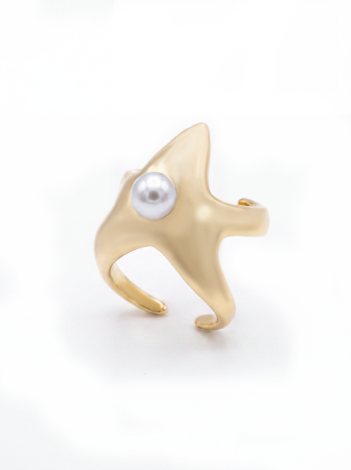 A gold starfish-shaped cuff featuring a single white pearl set in the center, photographed on a clean white background.